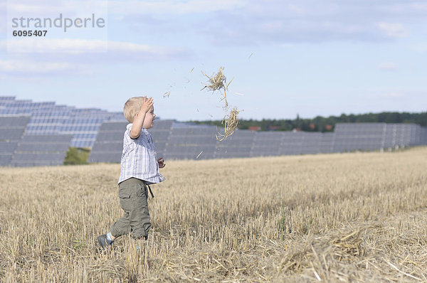 Boy running in grass  solar panels in background