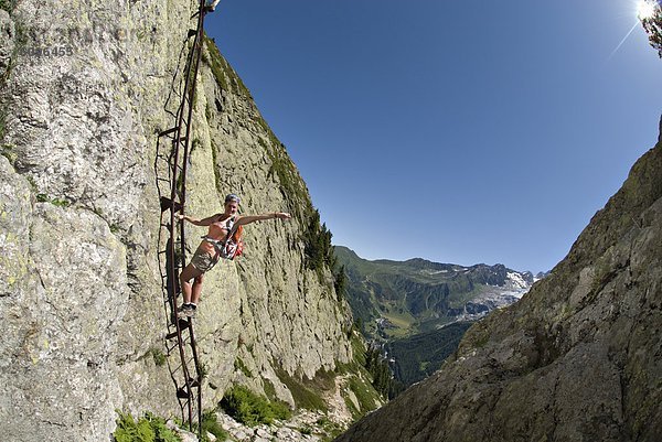 Frau  Pose  Leiter  Leitern  Steilküste  Alpen  groß  großes  großer  große  großen  Vorhängeschloß  schweizerisch