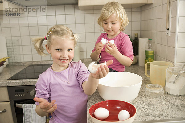 Mädchen kochen Kuchen in der Küche  lächelnd