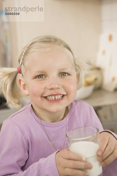 Mädchen trinkt Milchglas  lächelnd  Portrait