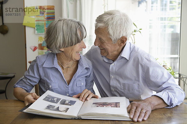 Germany  Bavaria  Senior couple with photo album  smiling