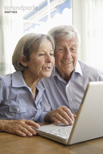 Germany  Bavaria  Senior couple using laptop at home