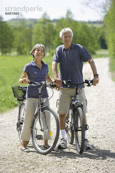 Germany  Bavaria  Senior couple with bicycle  smiling