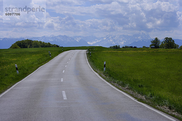 Germany  Bavaria  Empty country road with alps in background