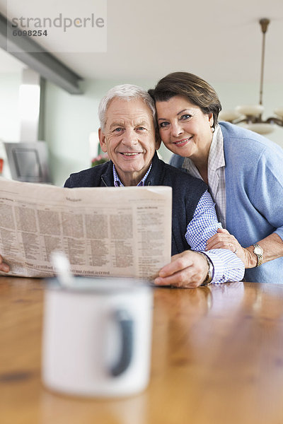 Senior Mann und Frau mit Zeitung  lächelnd  Porträt