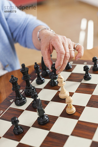 Senior woman playing chess game