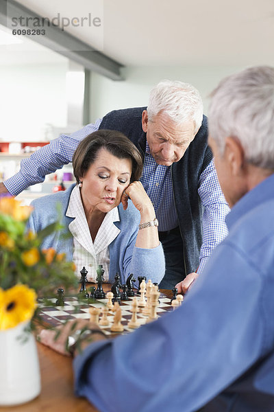 Senior men and woman playing chess