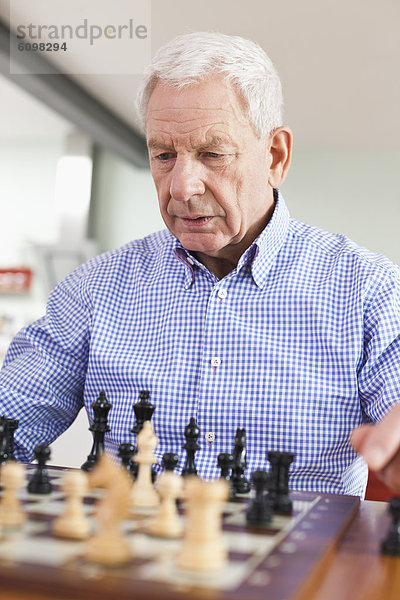 Senior man playing chess game