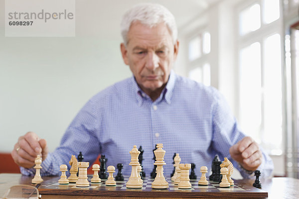 Senior man playing chess game