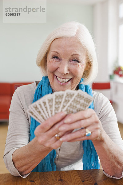 Senior woman playing cards  smiling