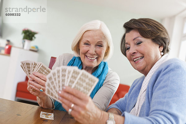 Senior women playing card game  smiling