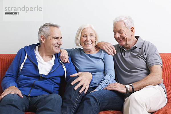 Senior men and woman sitting on couch  smiling