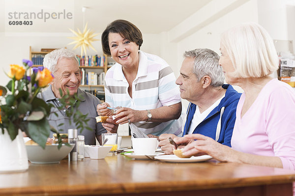Senior men and women eating food  smiling