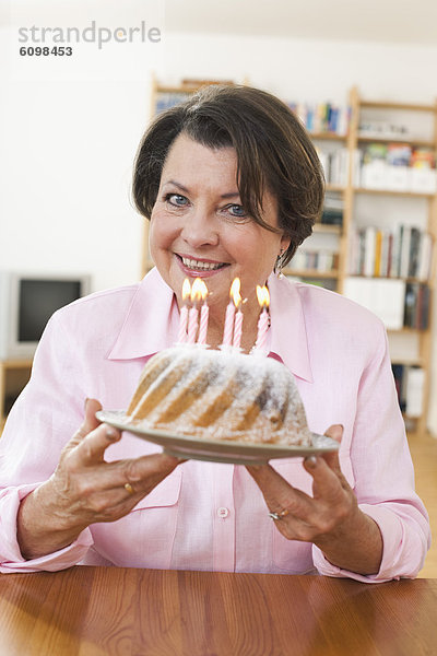 Senior woman holding birthday cake