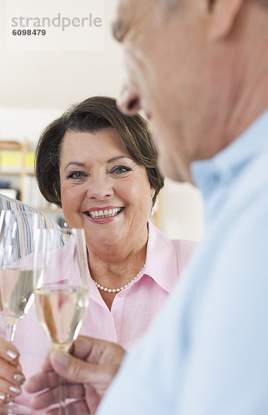 Senior man and woman drinking sparkling wine  smiling