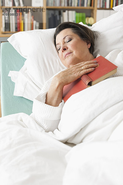 Seniorin entspannt auf dem Krankenbett
