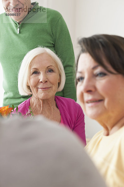 Men and women smiling together in apartment