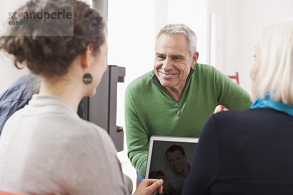 Men and women watching pictures on laptop