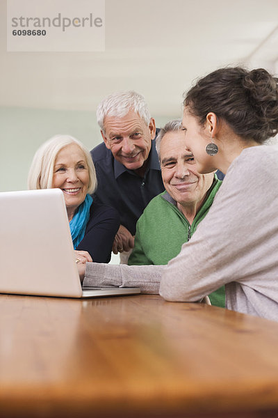 Men and women watching pictures on laptop