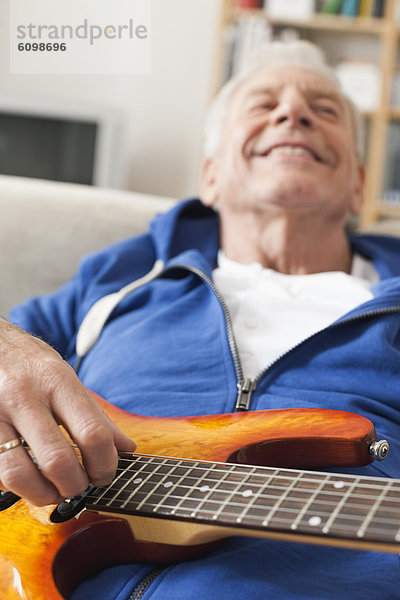 Senior Mann Zupfgitarre  lächelnd