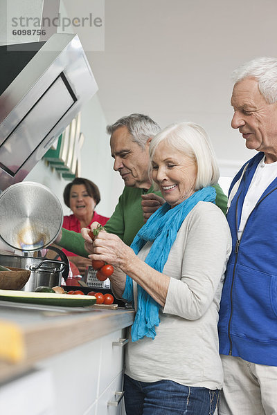 Seniorinnen und Senioren beim Kochen von Speisen