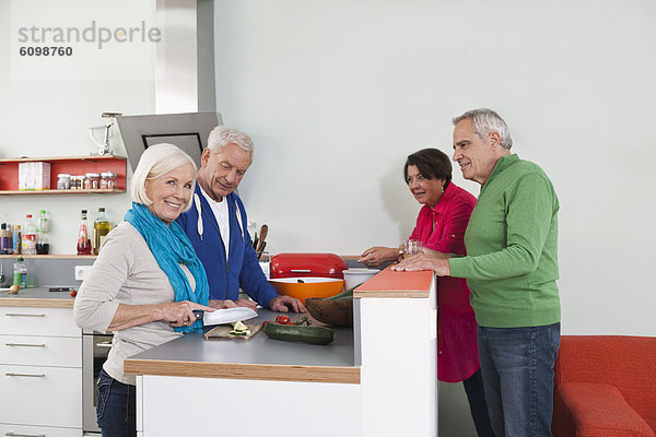 Seniorinnen und Senioren beim Kochen von Speisen