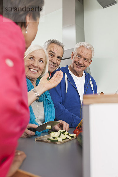 Seniorinnen und Senioren beim Kochen von Speisen