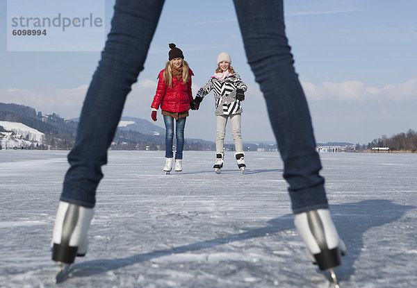 Österreich  Teenagermädchen auf Eisbahn stehend