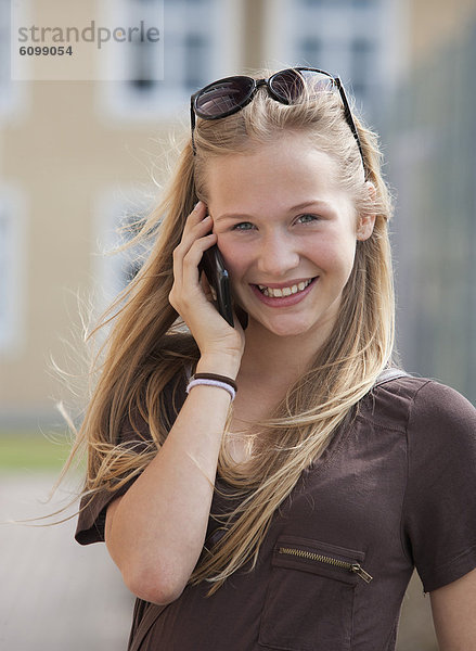 Österreich  Teenagerin am Handy  lächelnd  Portrait