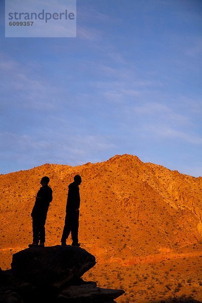 Haufen Felsbrocken stehend Portrait Selbstvertrauen Silhouette Hügel wandern 2 Backpacker Pose