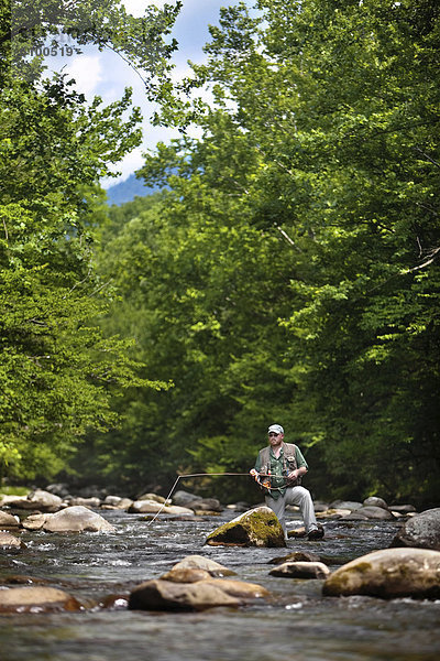 zwischen  inmitten  mitten  Felsbrocken  Fluss  dahintreibend  groß  großes  großer  große  großen  Fischer