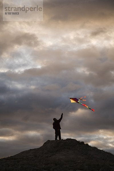 Farbaufnahme  Farbe  fliegen  fliegt  fliegend  Flug  Flüge  Frau  Silhouette  Hügel  über
