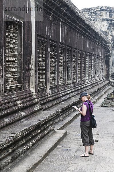 Reiseführer  Frau  Touristin  Angkor  Kambodscha  vorlesen