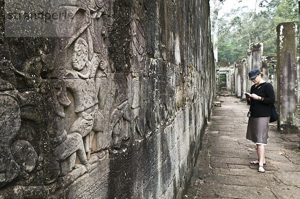 Reiseführer  Frau  Touristin  Angkor  Kambodscha  vorlesen