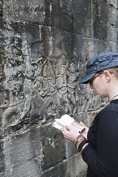 Reiseführer  Frau  Touristin  Angkor  Kambodscha  vorlesen