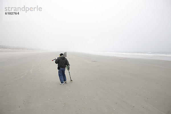 Mann  sehen  Strand  suchen  Nebel  Sand  Loch  graben  gräbt  grabend  Schatz  Metall