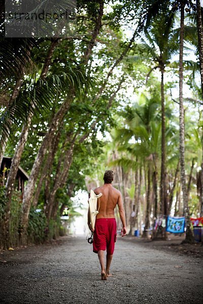 Mann  tragen  gehen  Surfboard  Fernverkehrsstraße  schmutzig  rot  Kleidung  Shorts