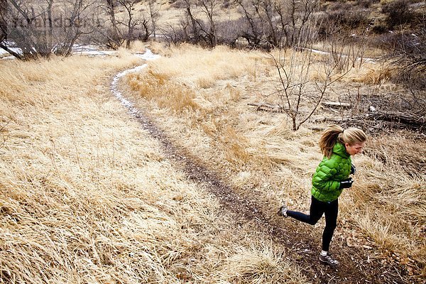 Kälte junge Frau junge Frauen Tag folgen rennen grün Jacke Gras Stausee