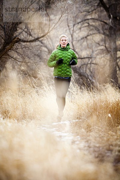 Kälte junge Frau junge Frauen Tag folgen rennen grün Jacke Gras Stausee