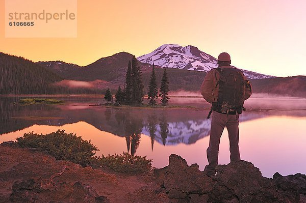 Man with backpack hiking  Sparks Lake in the morning.