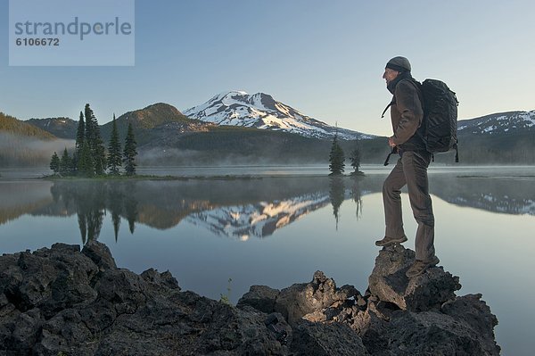 Man with backpack hiking  Sparks Lake in the morning.