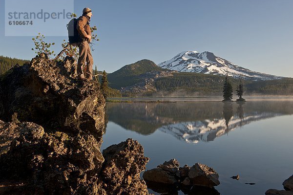 Man with backpack hiking  Sparks Lake in the morning.