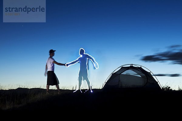 Mann  Reise  Beleuchtung  Licht  camping  streichen  streicht  streichend  anstreichen  anstreichend  Freund  schütteln