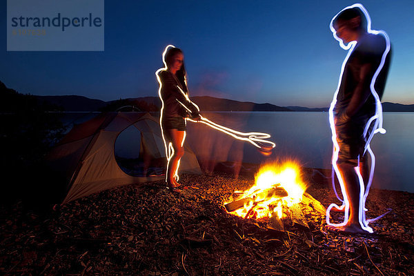Lagerfeuer  Wasserrand  stehend  Reise  Beleuchtung  Licht  See  camping  Zelt  streichen  streicht  streichend  anstreichen  anstreichend  vorwärts  Erwachsener  Idaho