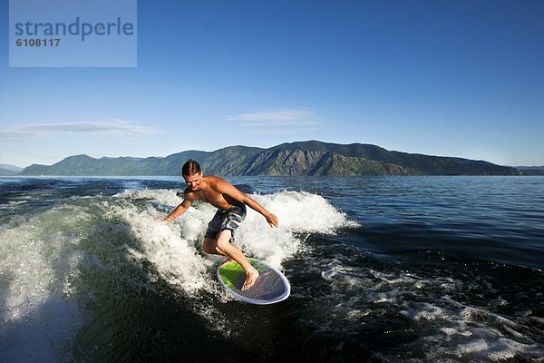 Wakeboarding  Wake boarding  hinter  Mann  Fröhlichkeit  Tag  lächeln  Boot  Sonnenlicht  Idaho
