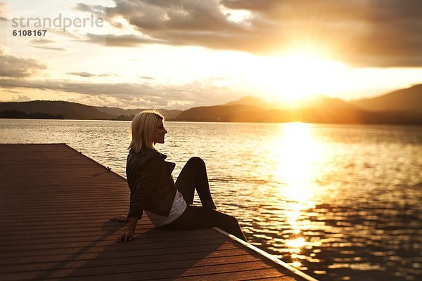 sitzend  Frau  Schönheit  sehen  Sonnenuntergang  über  See  Dock  jung  Idaho