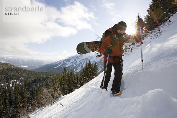 Snowboardfahrer  bergauf  Klettern  unbewohnte  entlegene Gegend