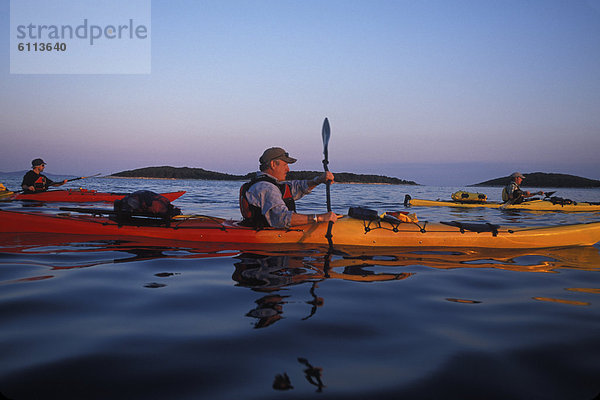 Kayakers paddle at sunset  Croatia