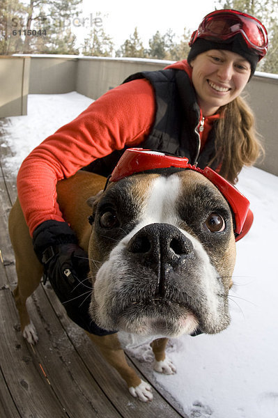 hoch  oben  nahe  Frau  Schutzbrille  Hund  jung  Kleidung  Schnee