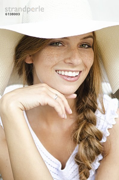 Lächelnde junge Frau mit Sonnenhut  Portrait